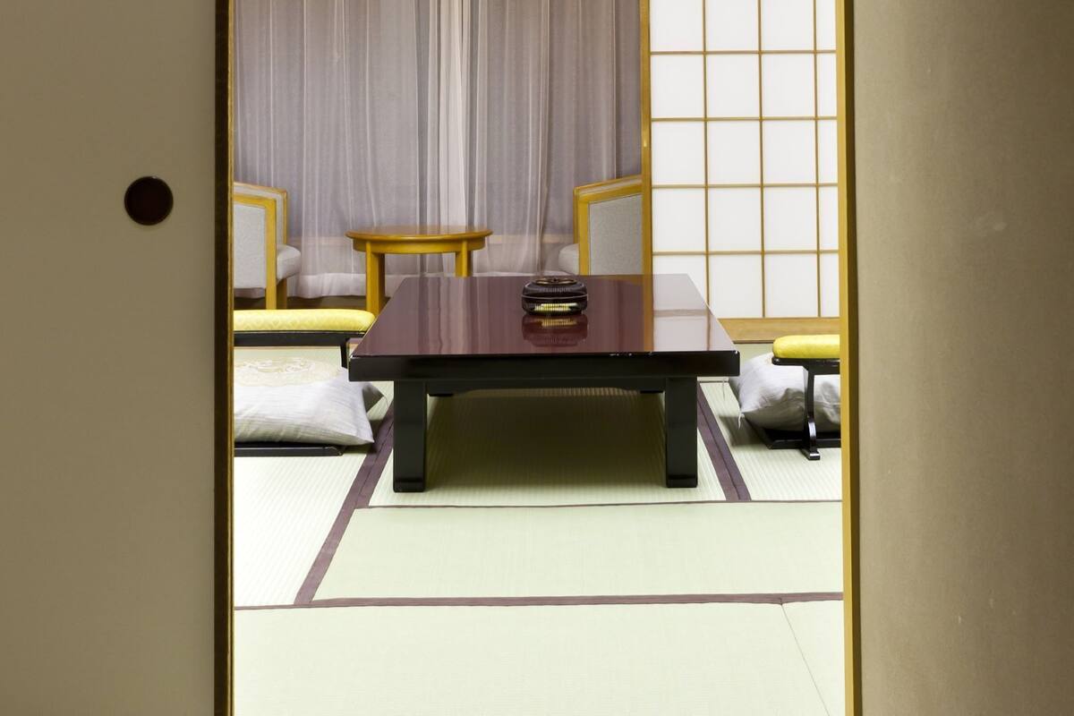 A traditional Japanese room with tatami flooring, a low table, and a shoji screen.
