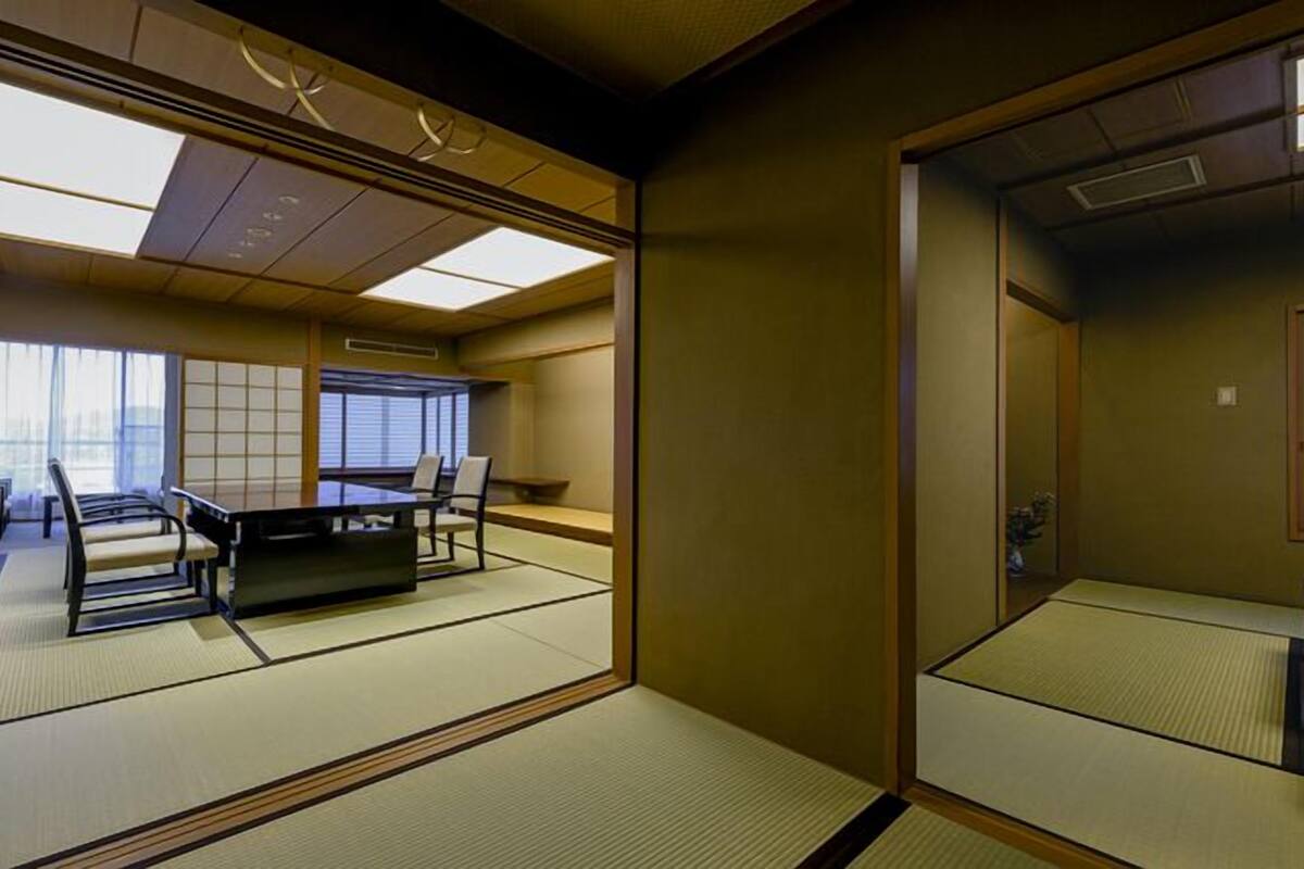 A traditional Japanese-style room with tatami flooring, a low table, and sliding doors.