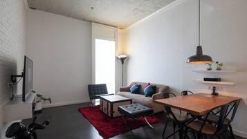 Una sala de estar moderna con un sofá, una mesa de comedor y un tapete rojo.