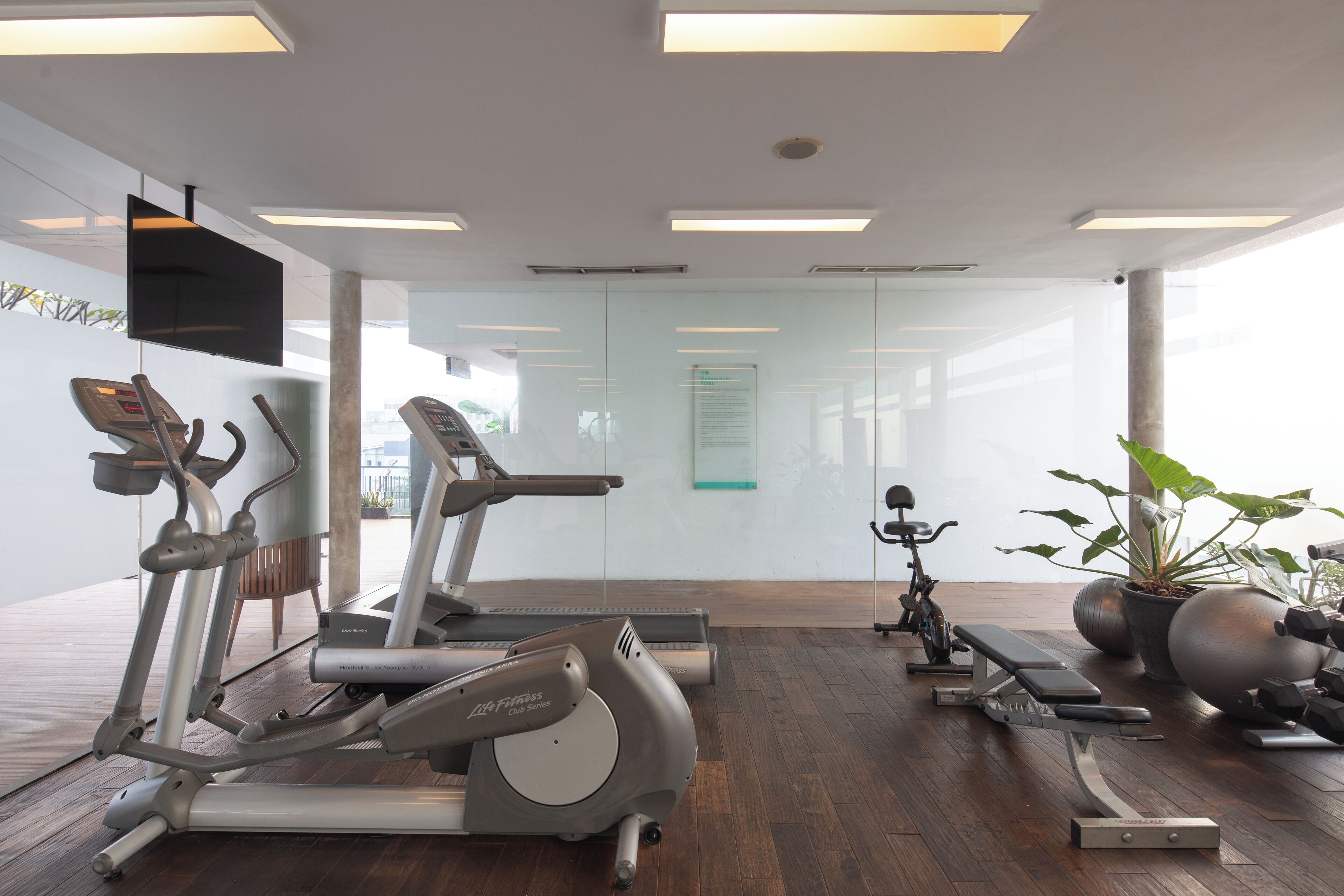 A modern gym with treadmills, elliptical machines, and a stationary bike.