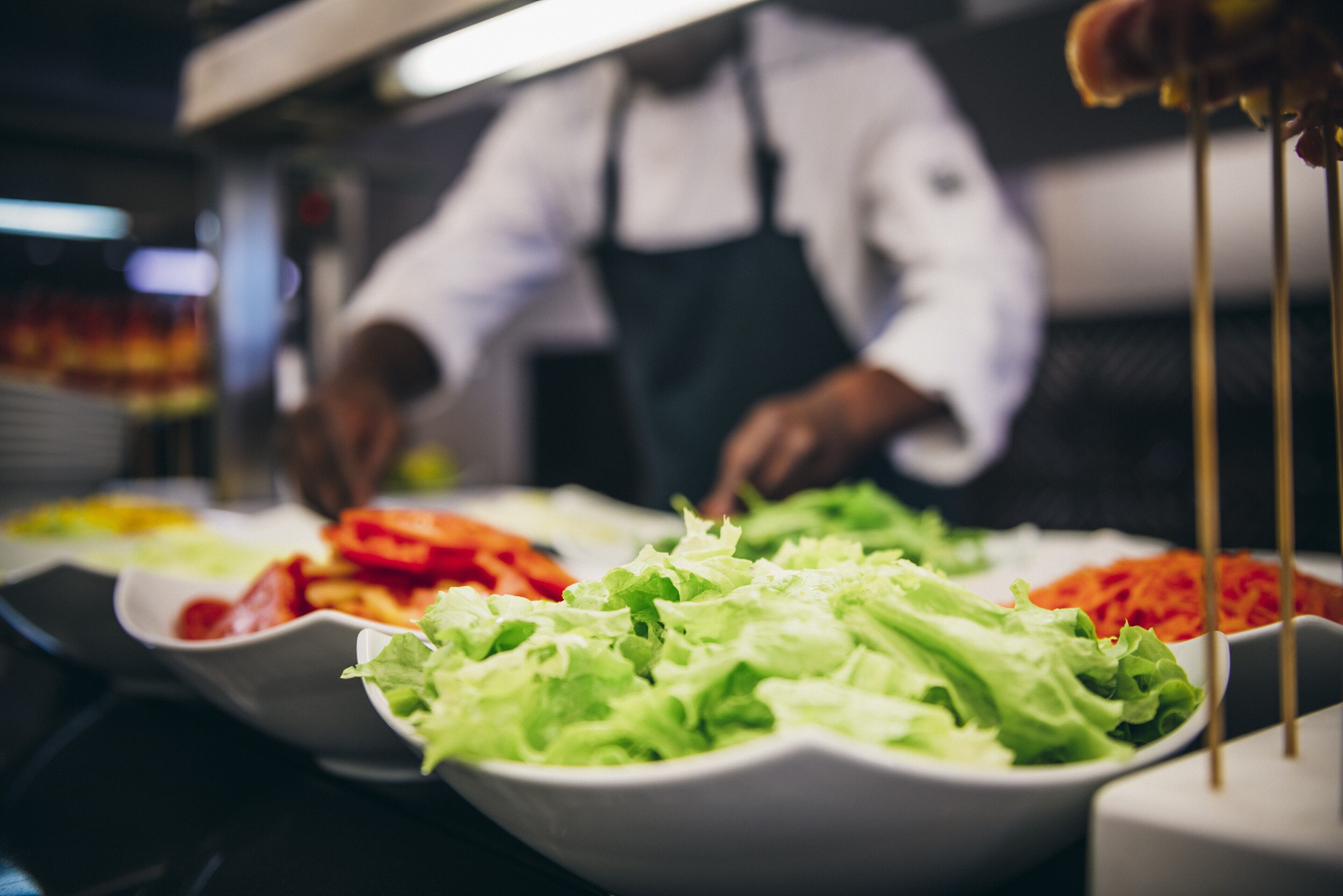 Un buffet proposant divers plats, notamment des salades et des légumes.