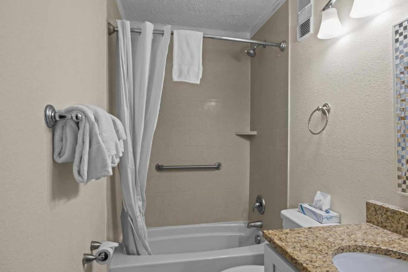 Un baño con ducha, inodoro y lavamanos.