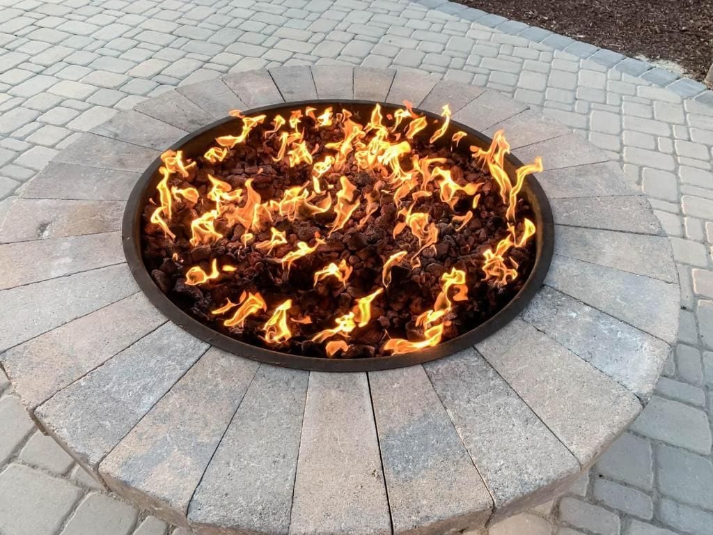 A circular fire feature surrounded by a stone border.