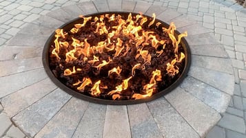 A circular fire feature surrounded by a stone border.