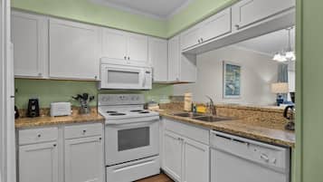 A kitchen with white cabinets, a microwave, a stove, and a dishwasher.