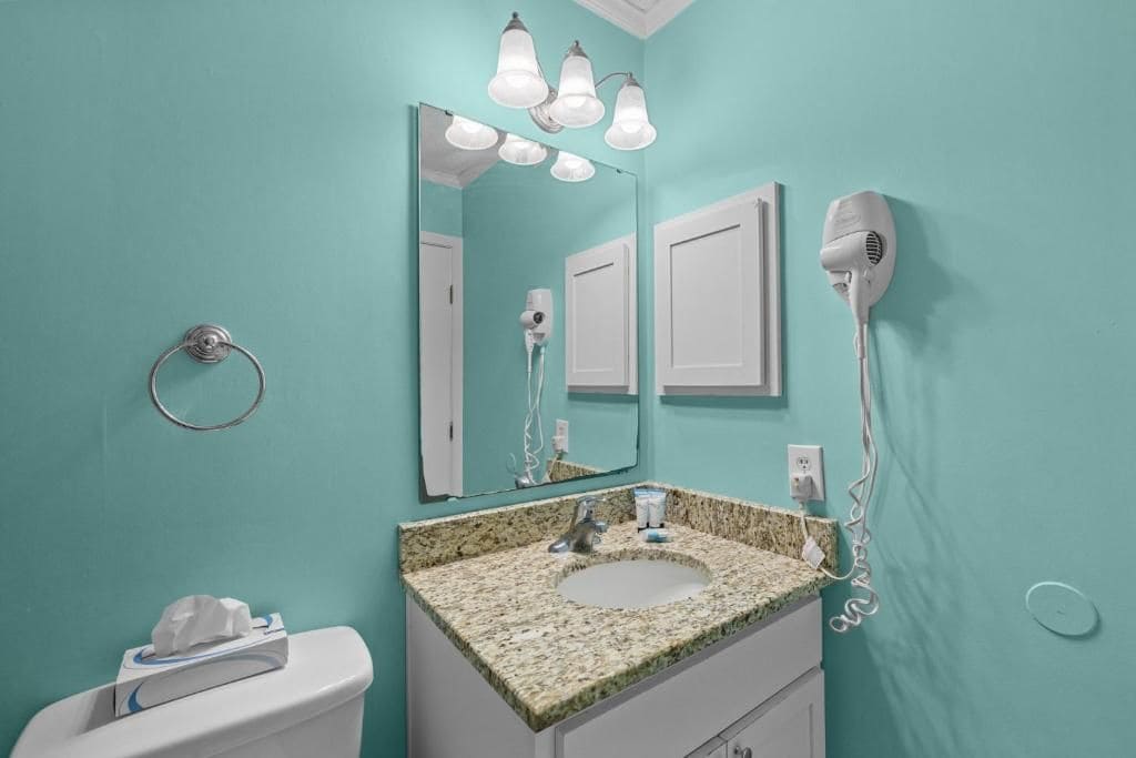A bathroom with a sink, mirror, and hairdryer.