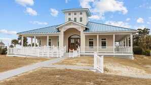 A two-story house with a covered porch and a metal roof. - A Place at the Beach (Atlantic Beach)