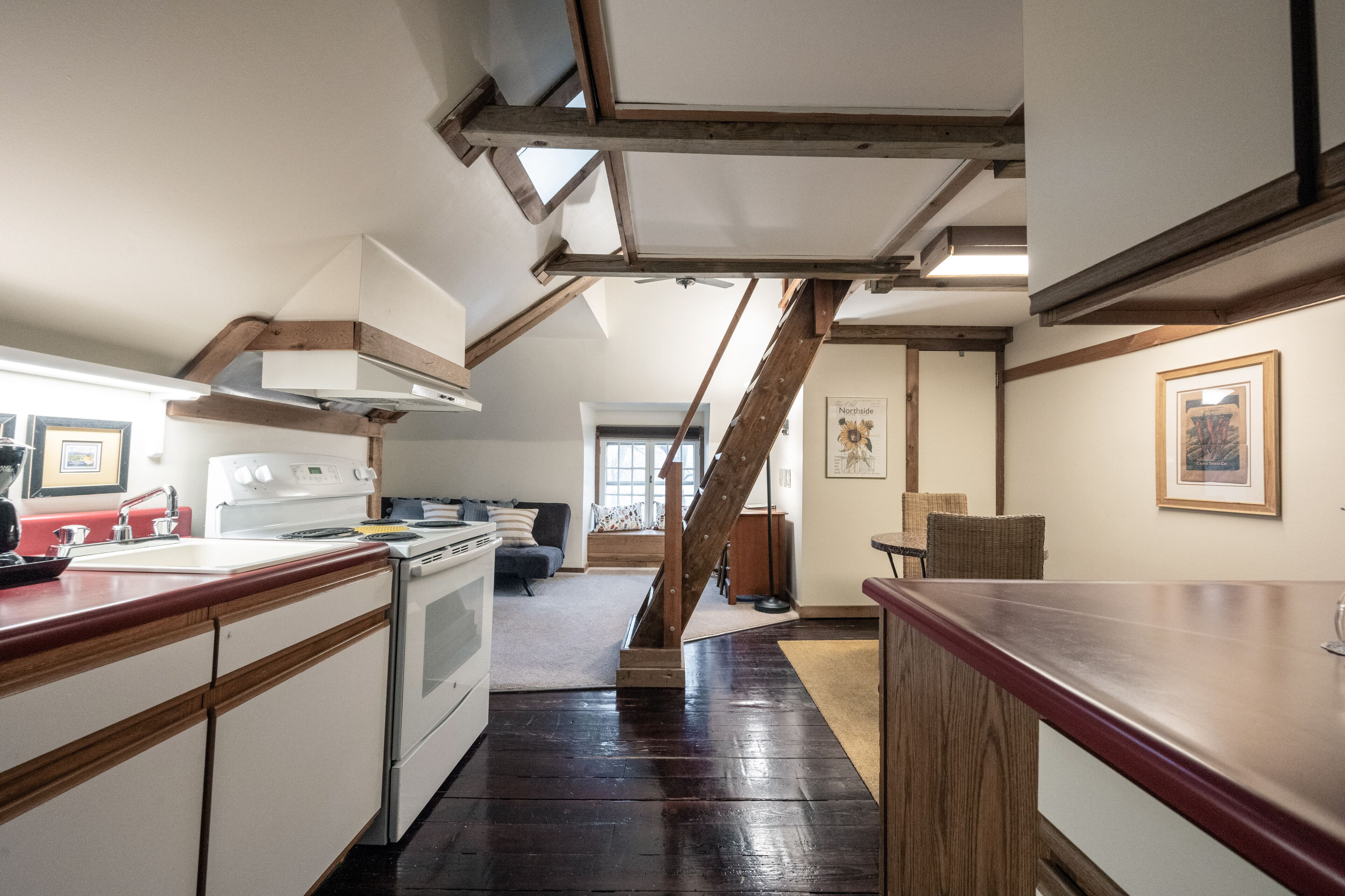 Eine Küche mit einer Holztreppe, die in einen Wohnbereich führt.