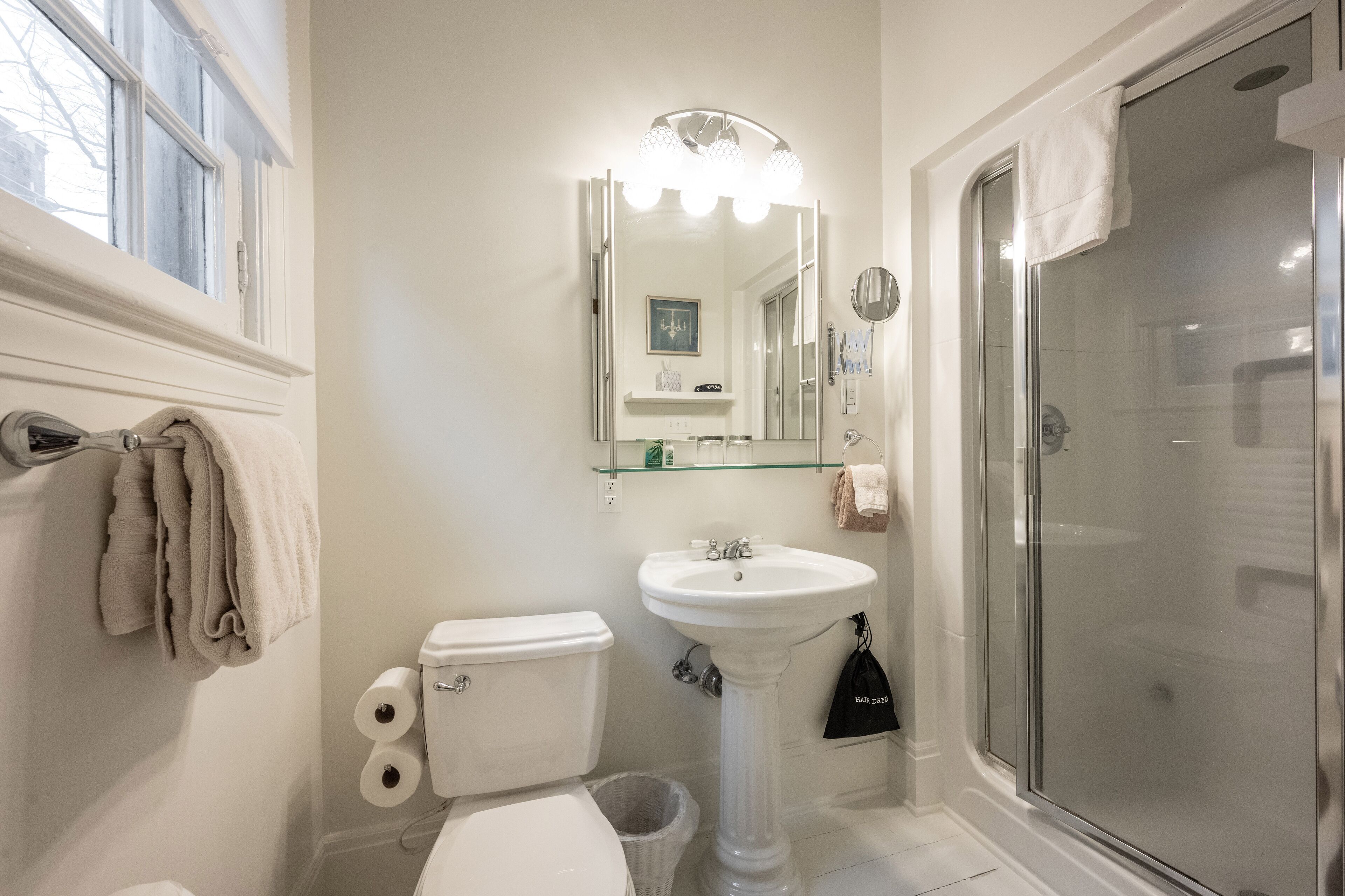Une salle de bain avec des toilettes, un lavabo et une douche.