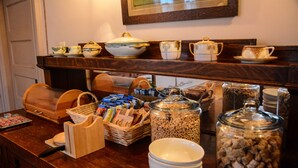 A breakfast buffet with various food items, including cereal and coffee.