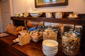 A breakfast buffet with various food items, including cereal and coffee.