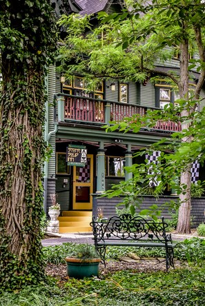 A green building with a checkered awning and a stone sign indicating a restaurant.