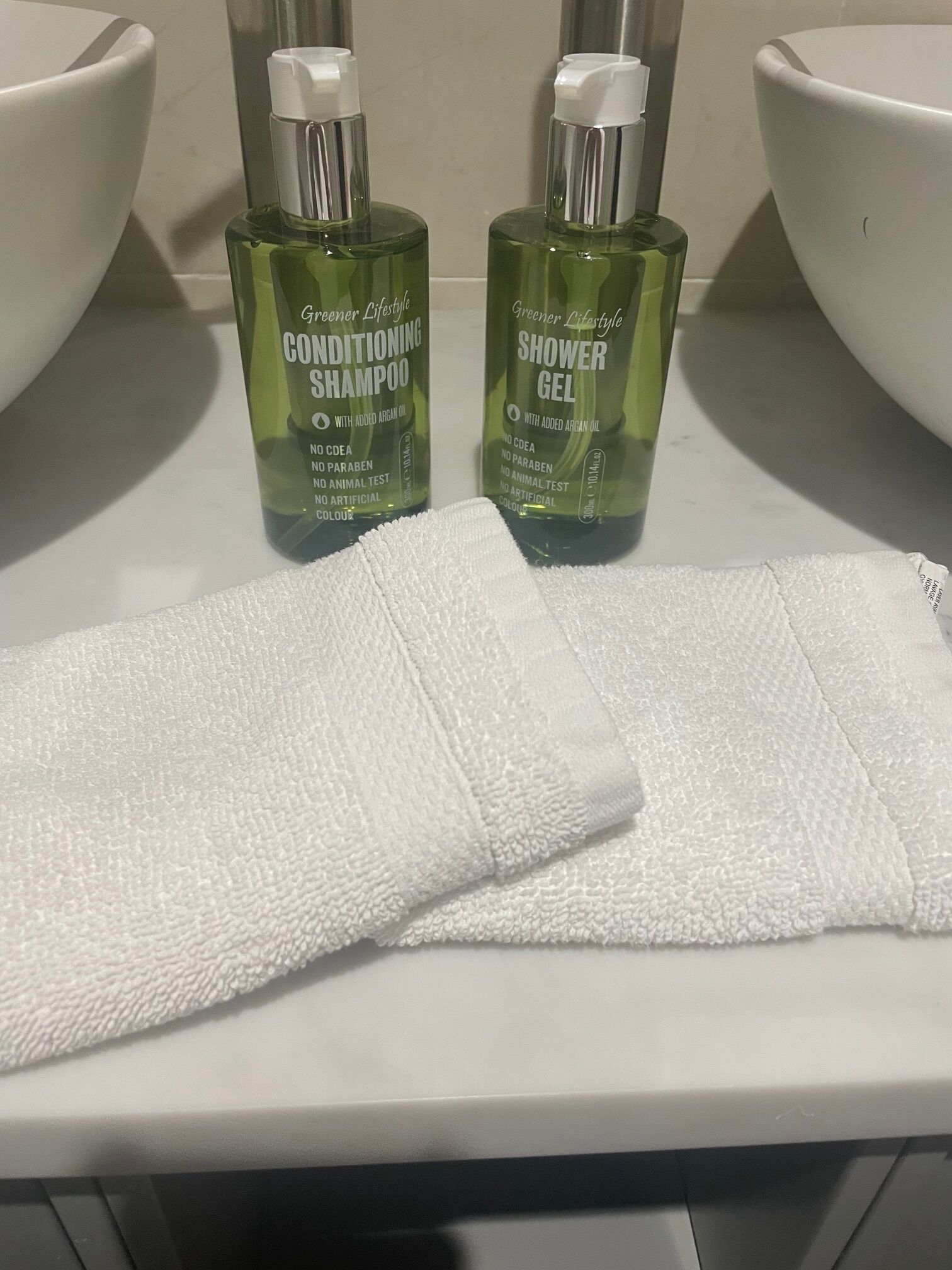 Two bottles of conditioner and shower gel on a bathroom counter.