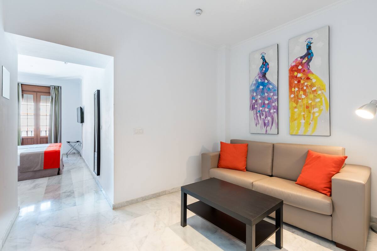 Una sala de estar moderna con un sofá, una mesita de centro y una obra de arte en la pared.