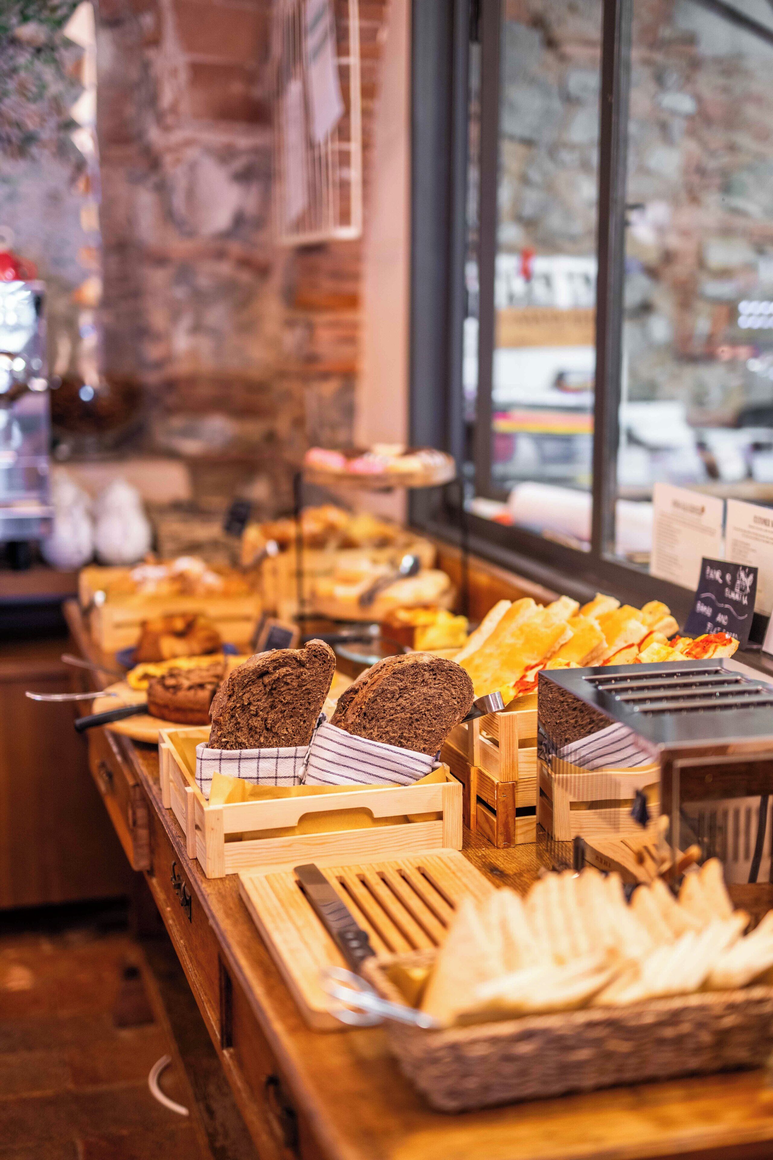 A bakery display with various breads and pastries.