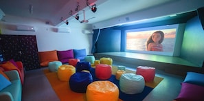 Relax in a comfortable seating area with colorful bean bags and enjoy the scenic ocean view on a large screen.