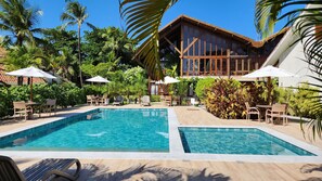 Relax by the resort's two pools surrounded by lush greenery and palm trees.