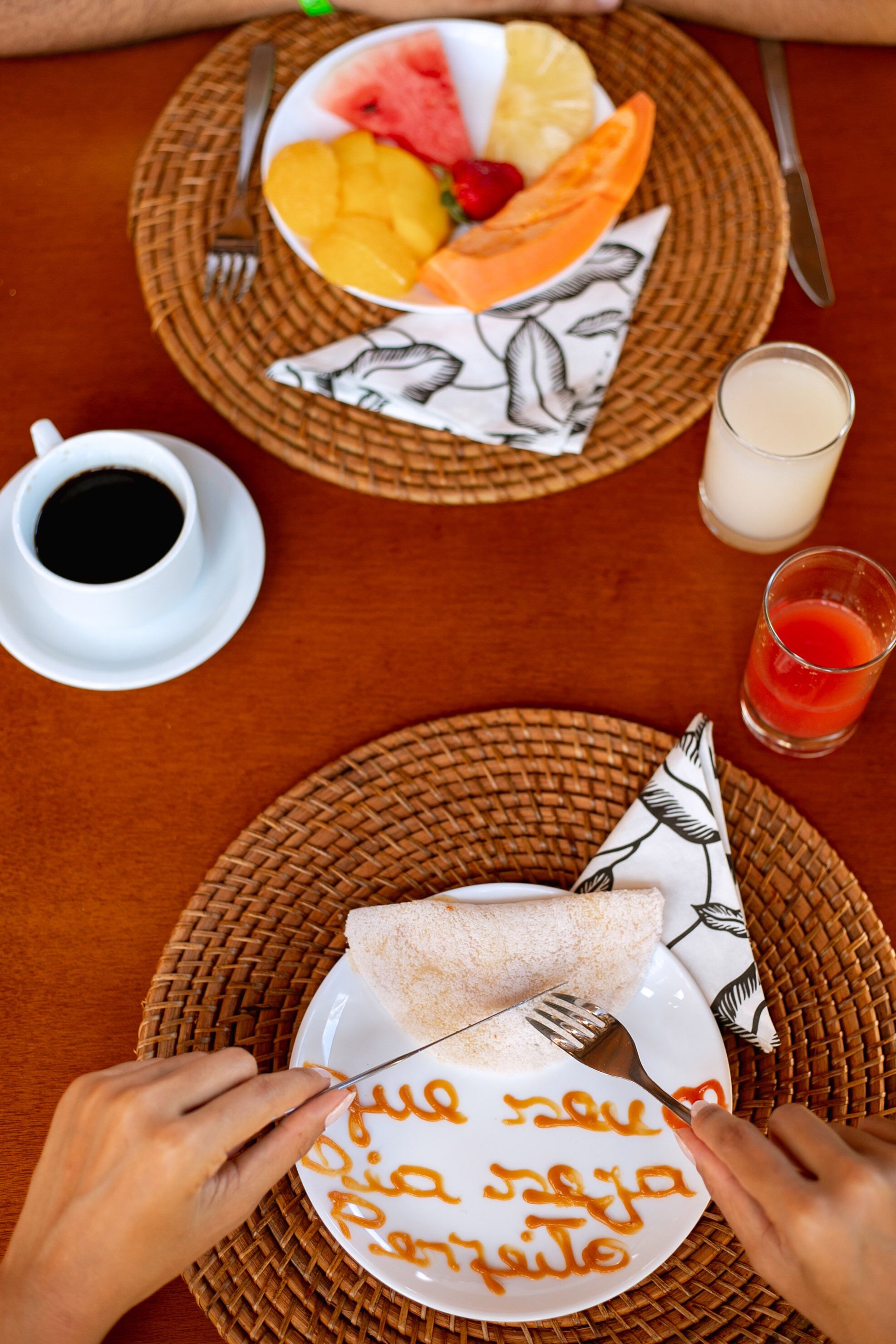Una mesa lista para el desayuno, con tostadas, una taza de café y un vaso de jugo.