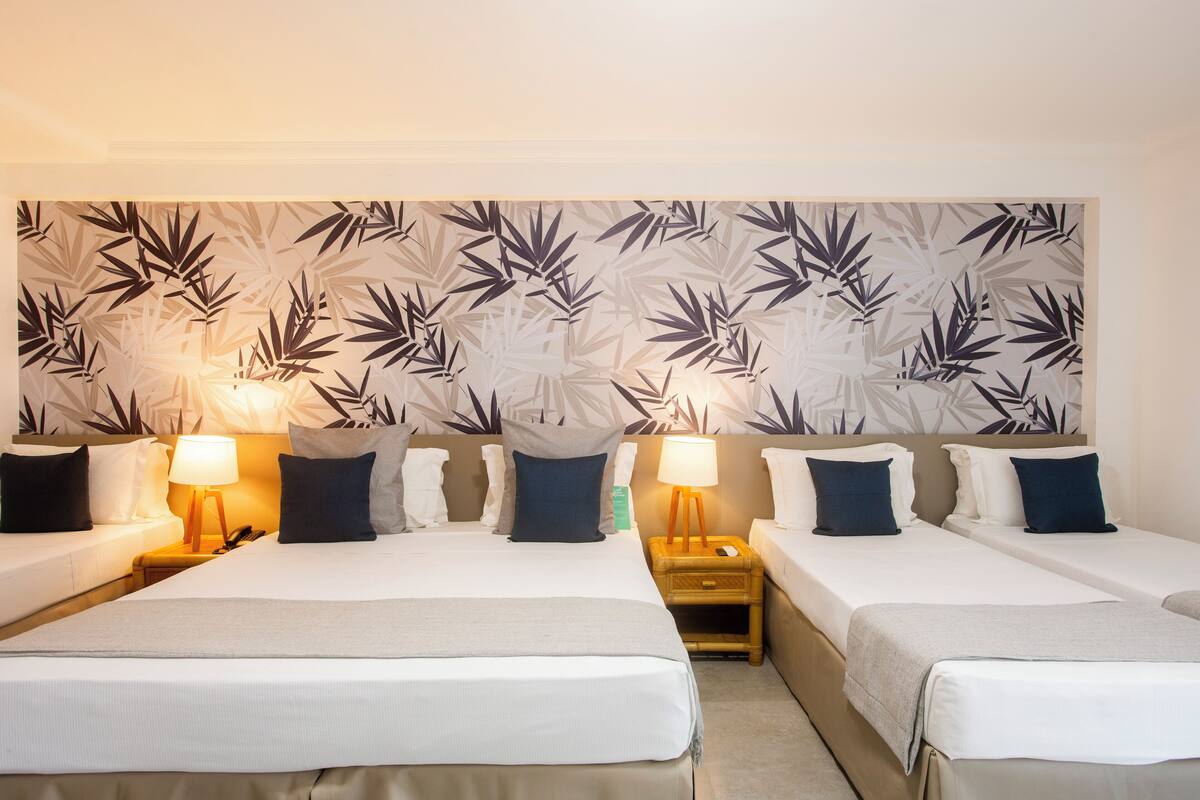 Ein Hotelzimmer mit zwei Betten, einer großen Wandmalerei, Nachttischlampen und einem Nachttisch.