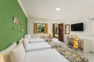 A hotel room with two beds, a desk, a television, and a view of the outdoors.