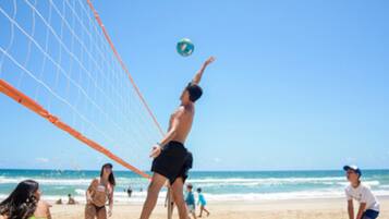 Na praia, areia branca, espreguiçadeiras, guarda-sóis