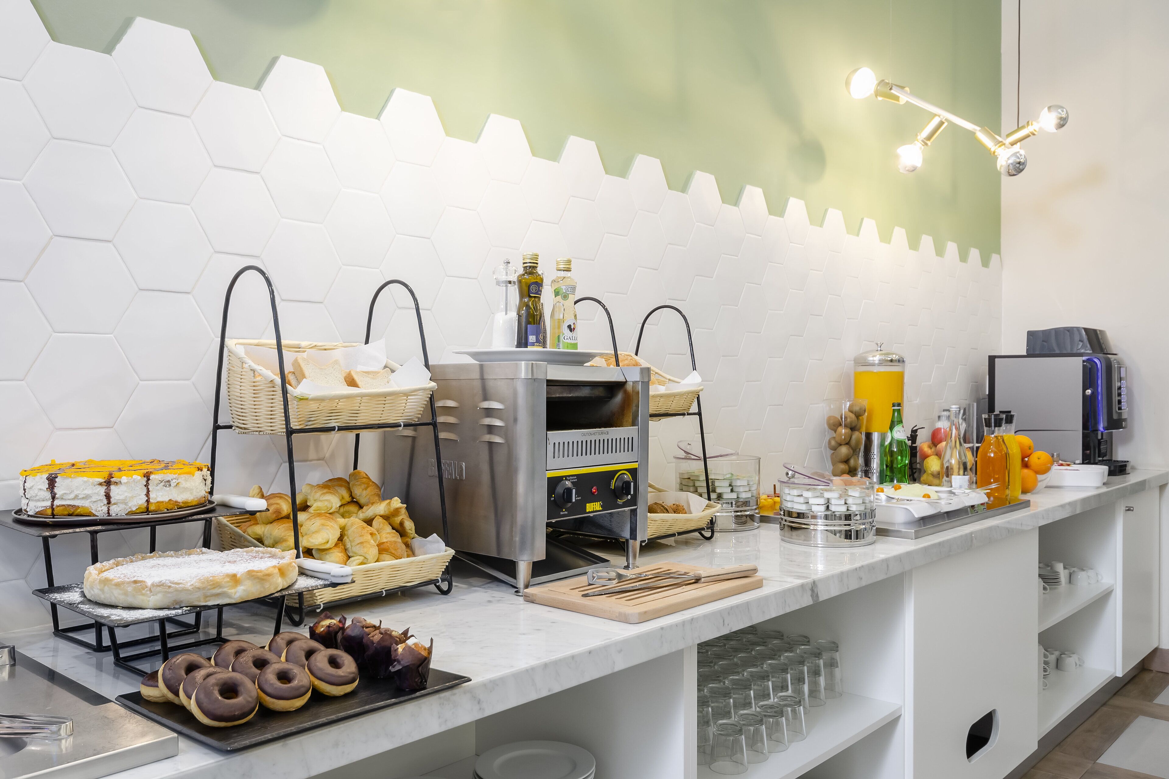A buffet setup with various food items, including pastries, donuts, and a beverage station.