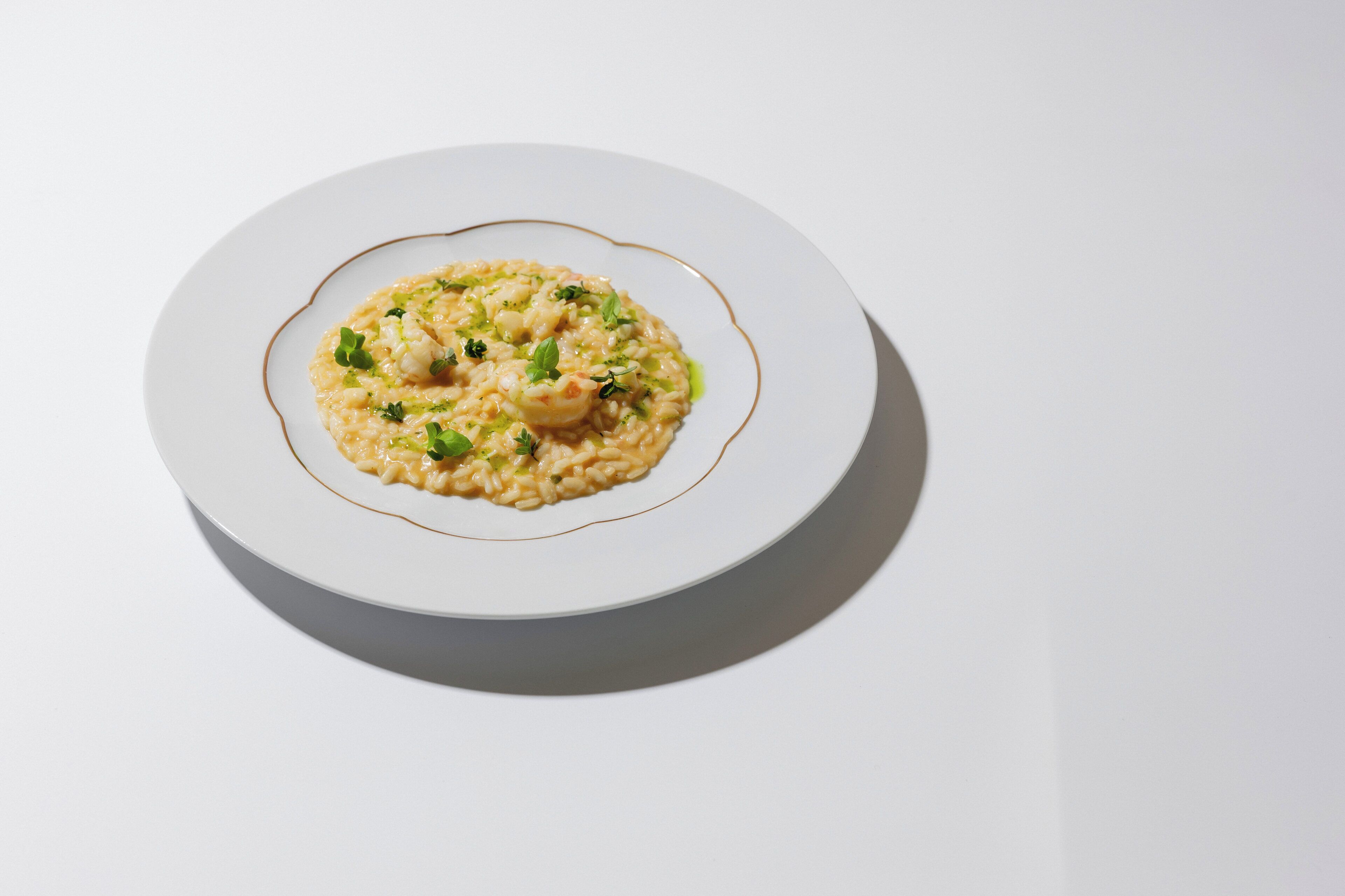 Un plato blanco con un risotto de mariscos.