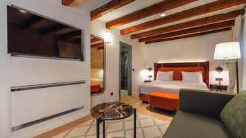 Een moderne hotelkamer met een groot bed, een bank, een kleine tafel en een televisie.