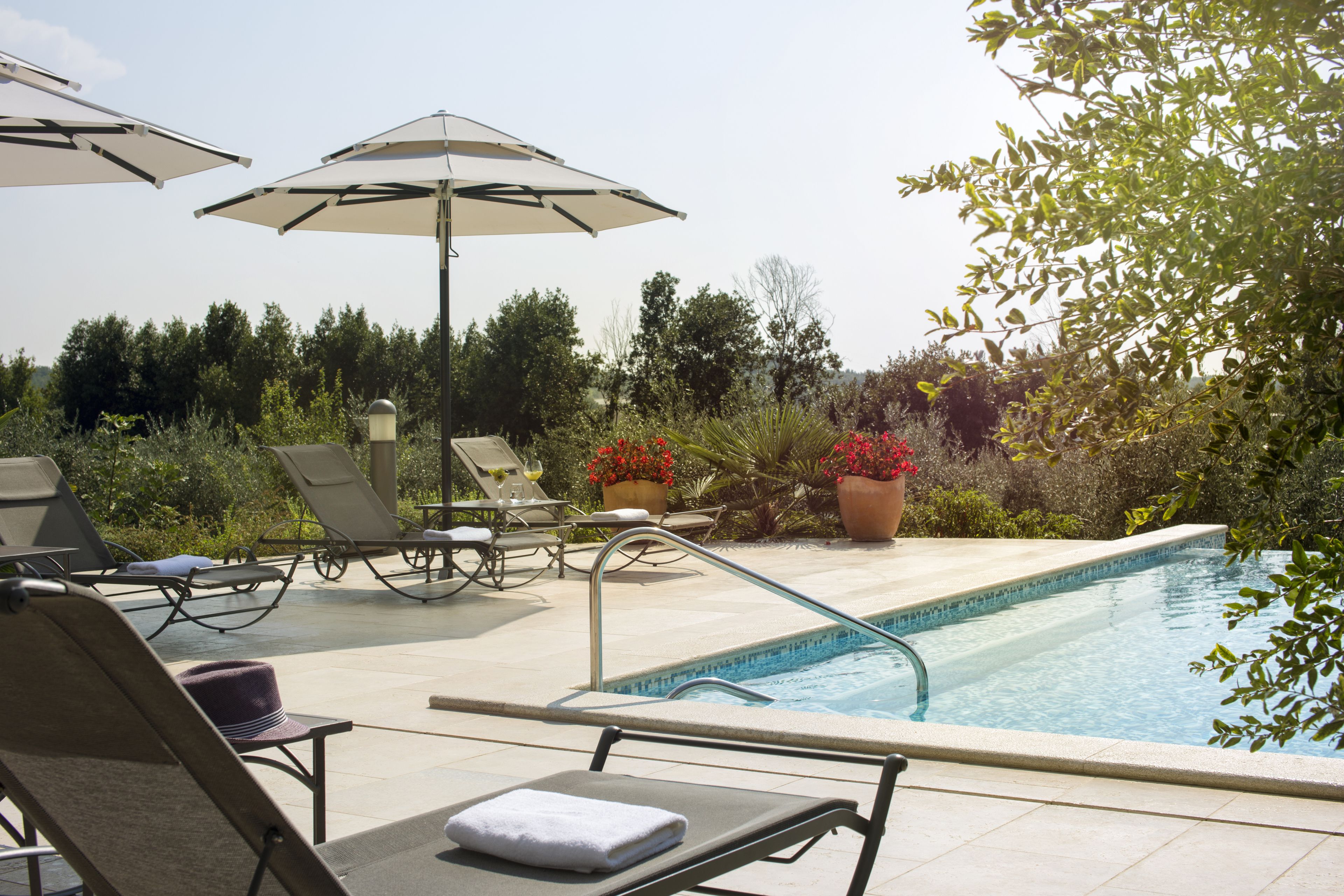 Una piscina techada, una piscina al aire libre, sombrillas