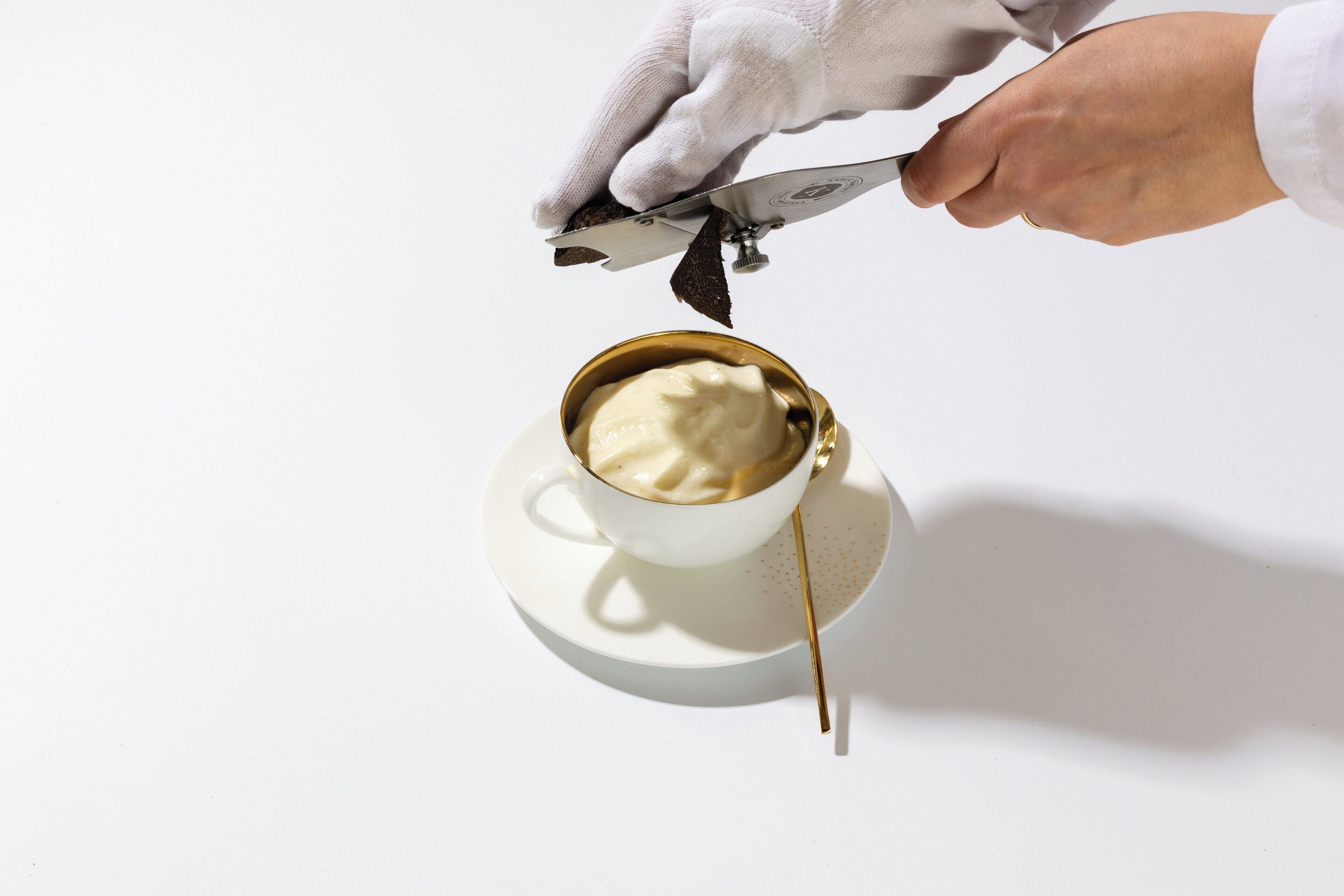 A hand using a tool to cut a pastry.