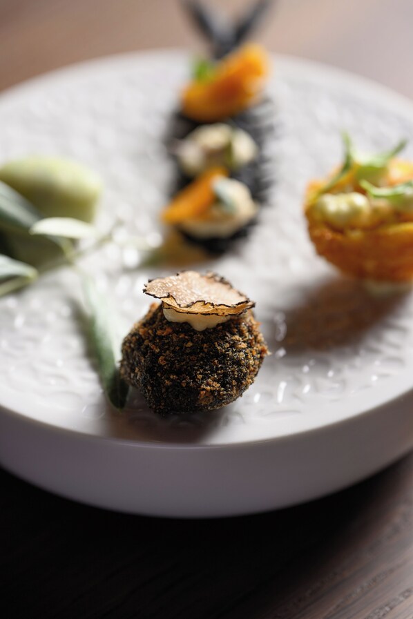 A plate with various food items, including a mushroom, a green vegetable, and a piece of bread.