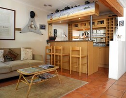 Ein gemütliches Wohnzimmer mit einer Holztresorecke, einer Couch und einem Couchtisch mit Zeitschriften.