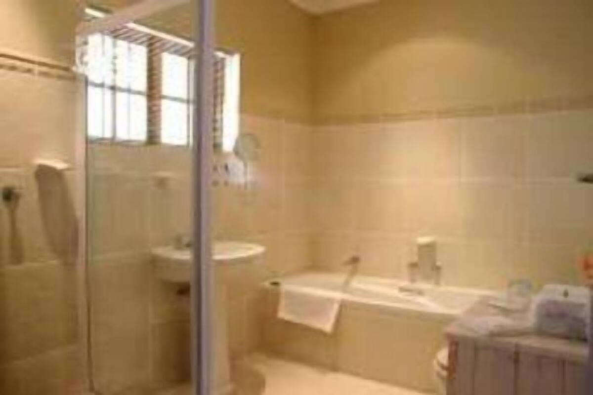 Un baño con cabina de ducha de vidrio, bañera y lavamanos.