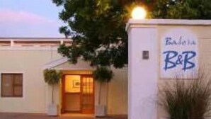 Un edificio con un letrero que dice "B&B" y una puerta que da a la entrada.