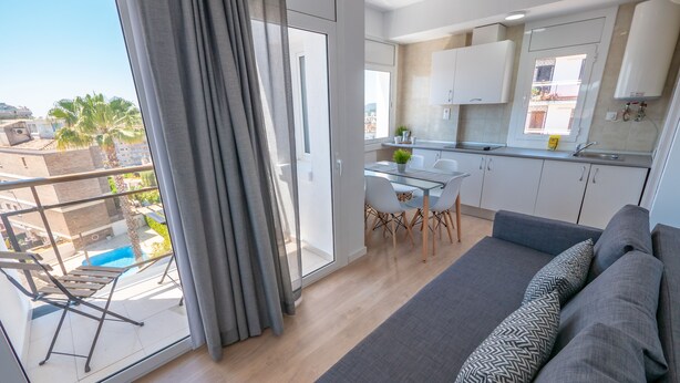 Un appartement moderne doté d’un balcon, d’un coin repas et d’un salon.