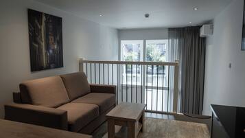 Estudio, 1 cama Queen size y sofá cama | Área de sala de estar | Televisión