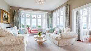 A spacious living room with two sofas, a coffee table, and a view through large windows.