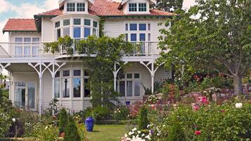 Et toetagers hus med rødt tegltag, hvide vægge og en balkon.