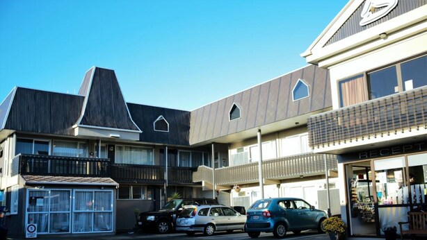 A multi-story building with a modern architectural design, featuring a mix of residential and commercial spaces. - Kiwi Studios Motel (Palmerston North)