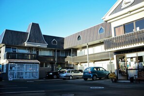 Un edificio de varios pisos con un diseño arquitectónico moderno, que combina espacios residenciales y comerciales.