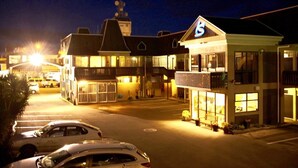 A motel with a prominent '5' sign, multiple-story buildings, and a parking lot with cars. - Kiwi Studios Motel (Palmerston North)