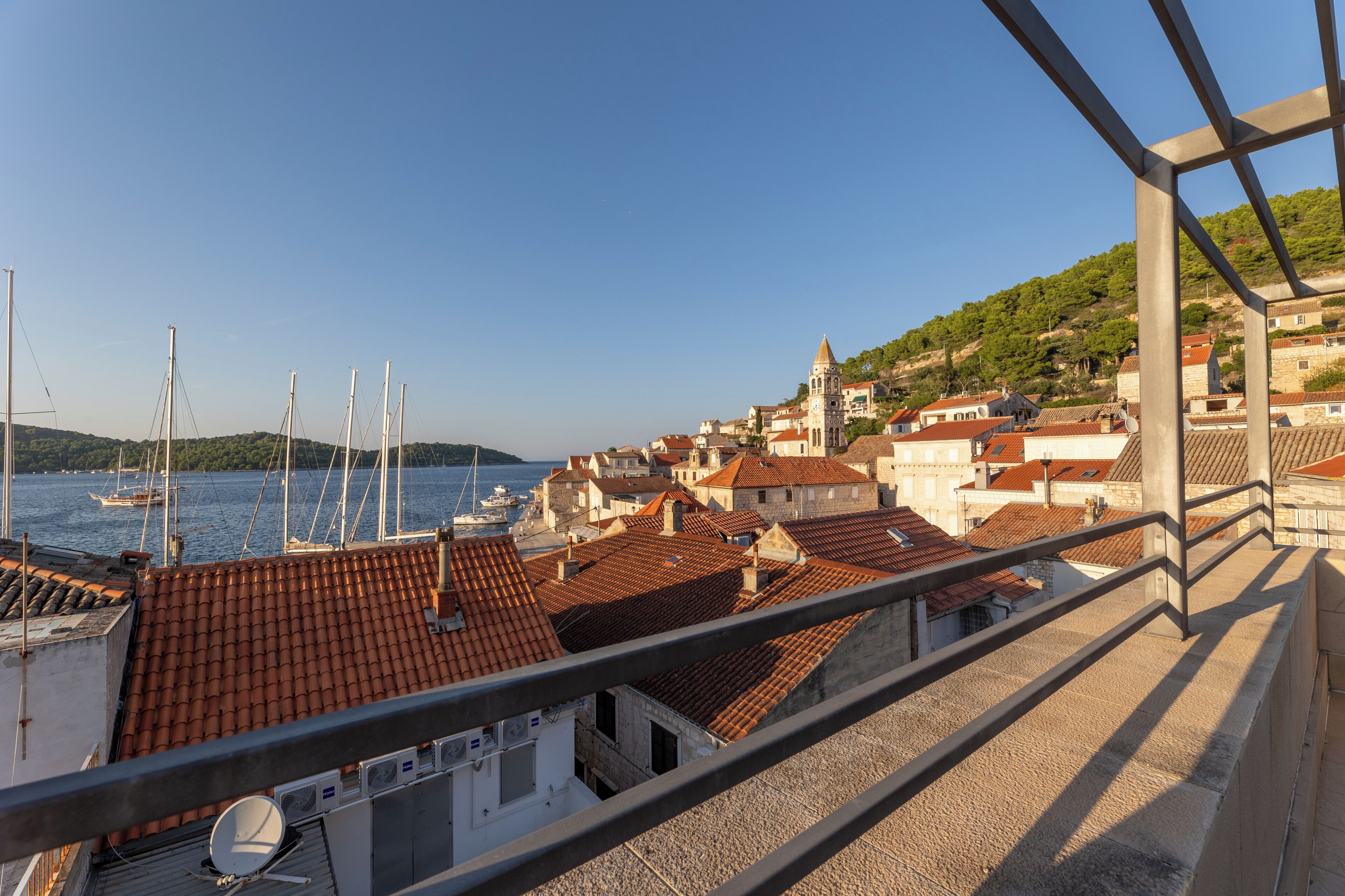 A coastal town with buildings, a church, and boats in the harbor.