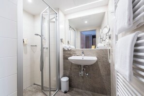 Comfort driepersoonskamer | Badkamer | Een douche, een haardroger, handdoeken