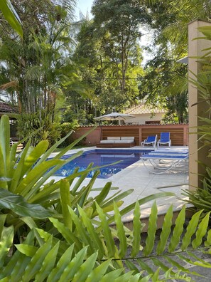 Een buitenzwembad en ligstoelen