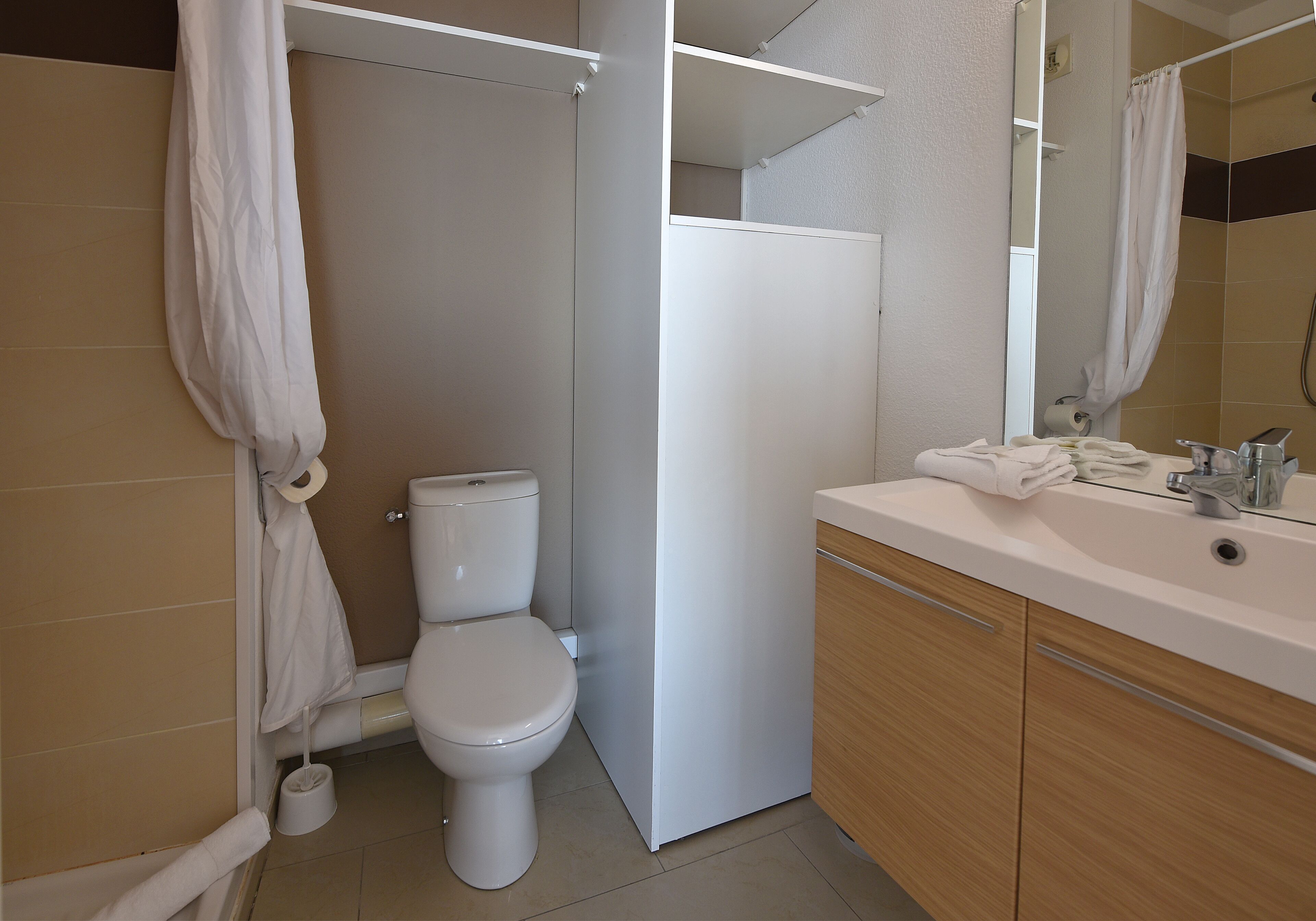 A modern bathroom with a toilet, shower, and sink.