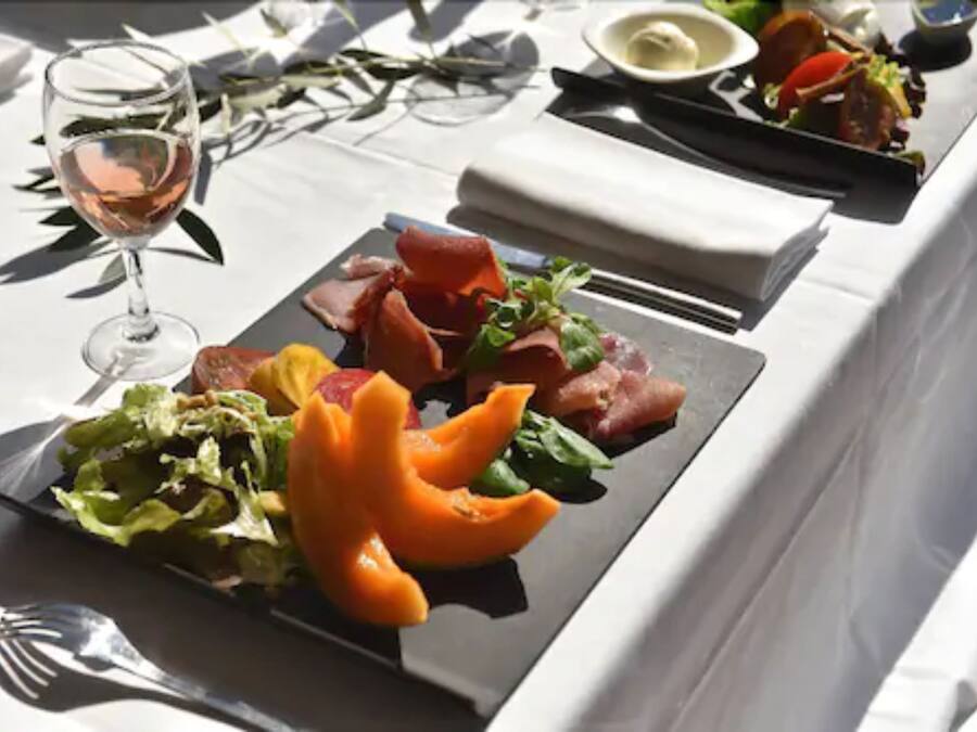 Une table dressée avec des assiettes remplies de nourriture, un verre de vin et des couverts.