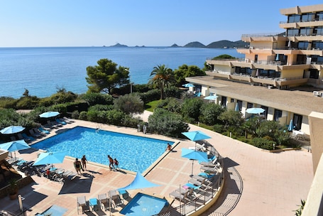 Una piscina al aire libre de temporada, sombrillas