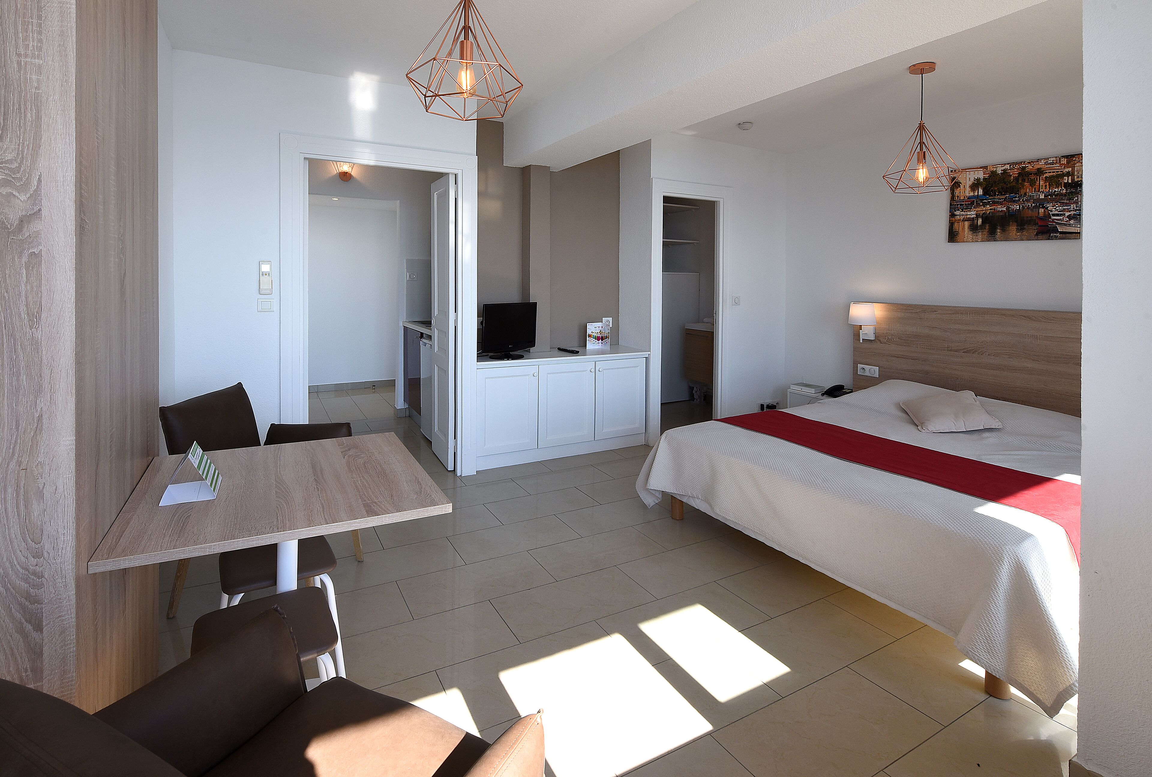 Ein modernes Hotelzimmer mit Bett, Schreibtisch und Essecke.