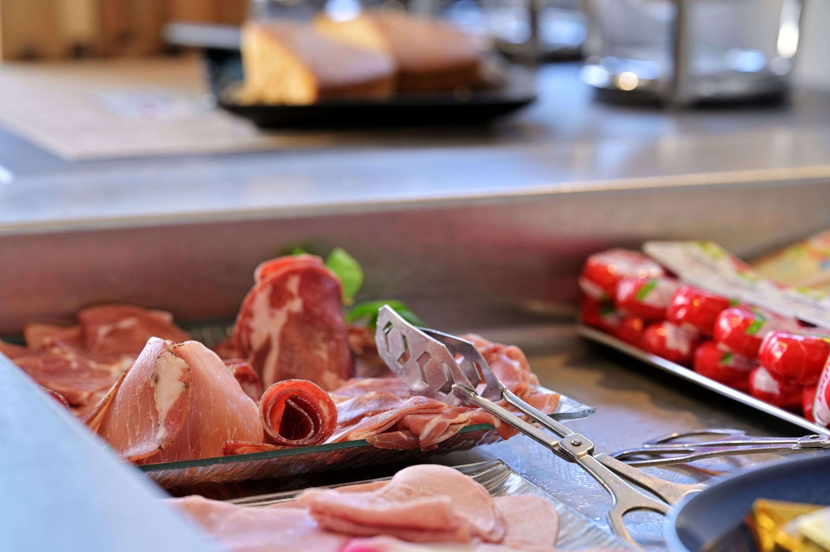 Una variedad de carnes y verduras en una mesa de buffet.
