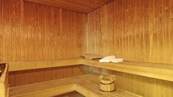 Een houten sauna met banken en een handdoek op een van de banken.